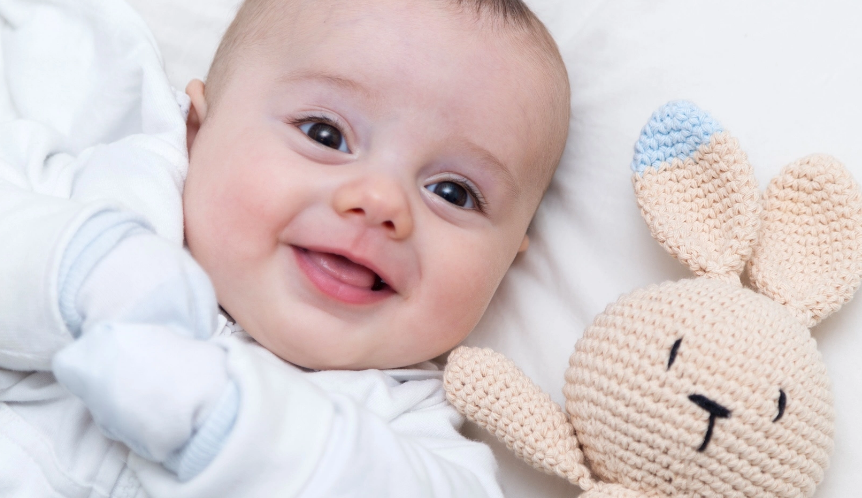 smiling baby with stuffed bunny